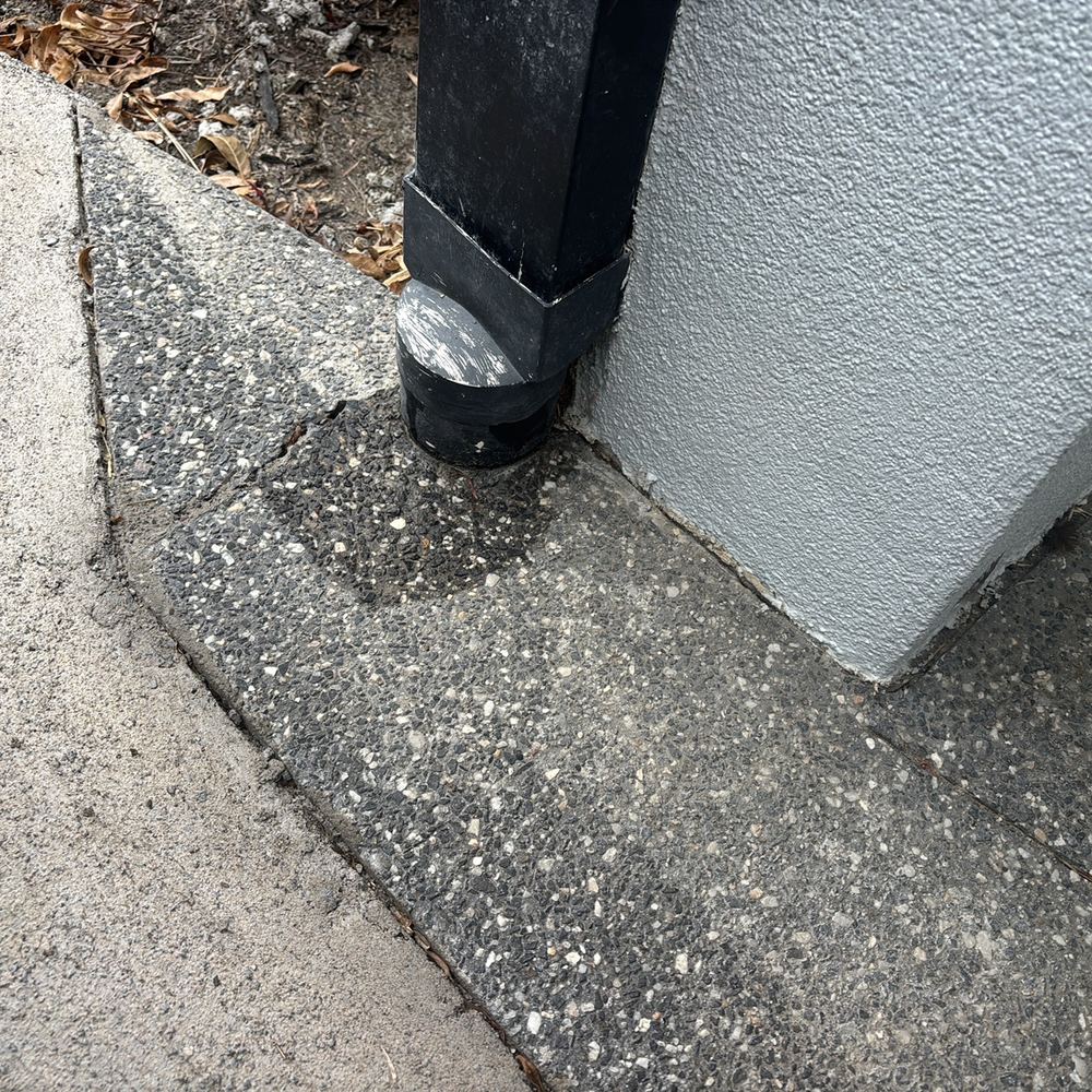 Dented downpipe leaking beside the front porch, found during a defect investigation inspection in South Kingsville